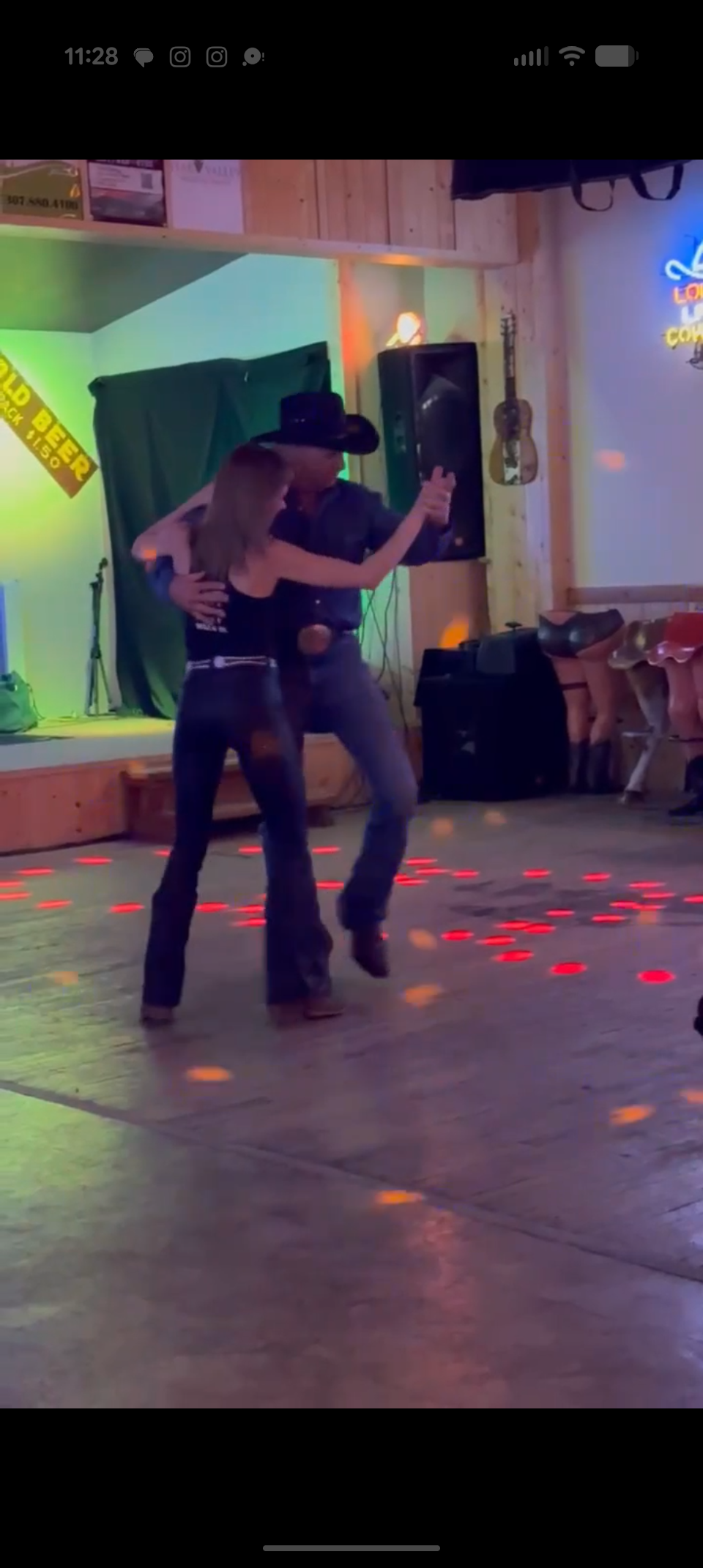 A couple two-stepping under the neon