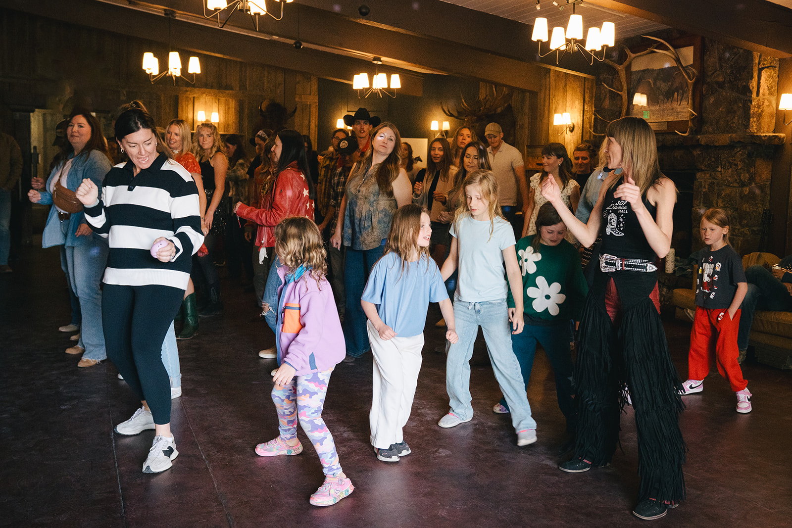 A room of all ages learning a line dance